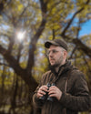 Dominic von Waidreich als Jaeger im Wald mit Fernglas als authentisches Portrait fuer Webdesign im Jagd- und Waffenumfeld